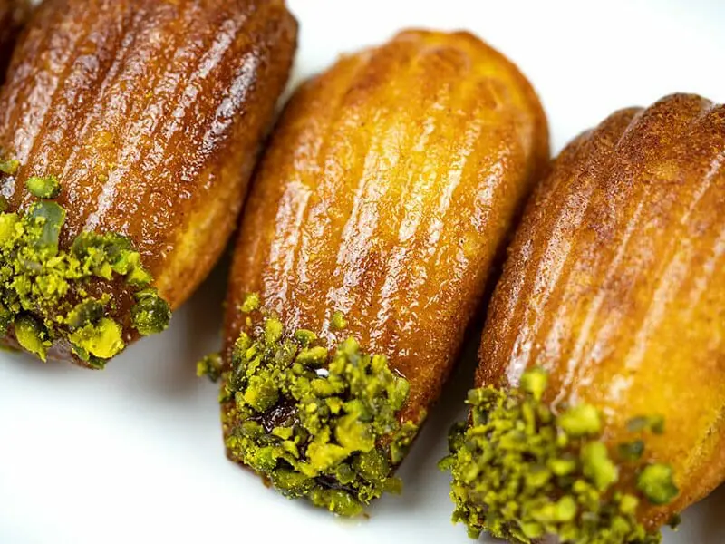 Golden saffron madeleines with a delicate crumb, served on a white plate
