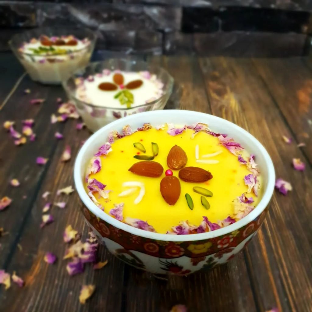 Golden saffron pudding served in small dishes with a nut garnish