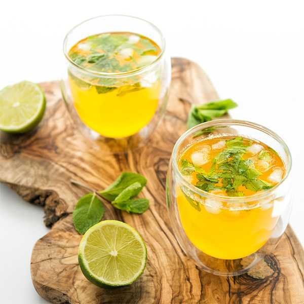 Pale golden saffron lemon water with a lemon slice and ice cubes