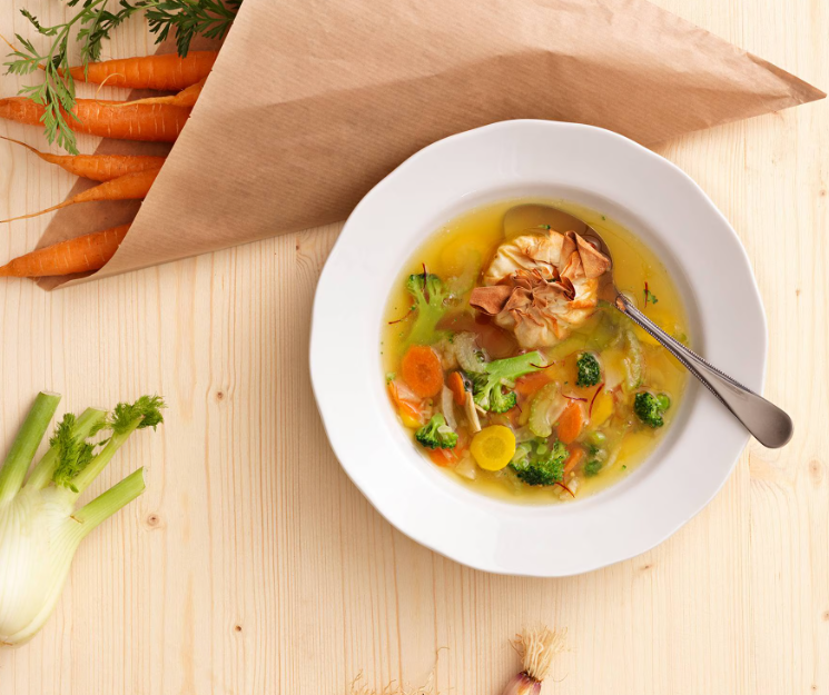 Serving suggestion for a clear saffron vegetable soup.