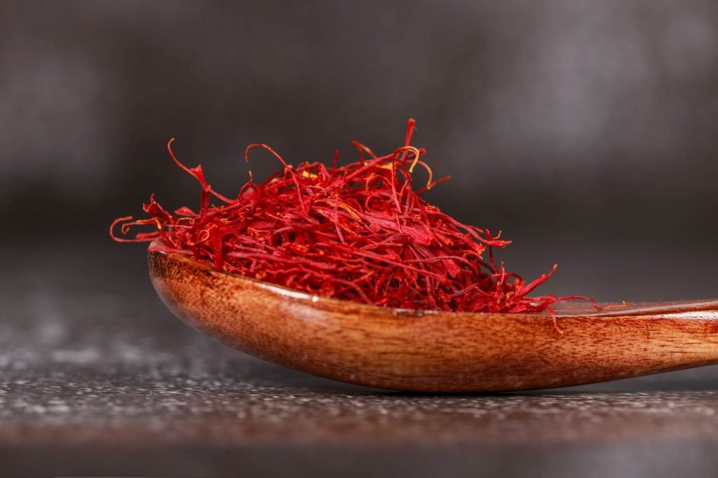 Red saffron threads on a wooden spoon