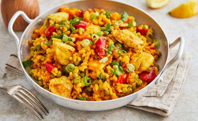 Spanische Paella mit Safran, Garnelen, Muscheln, Hähnchen und Gemüse – traditionelles Gericht aus Valencia mit goldgelber Farbe.