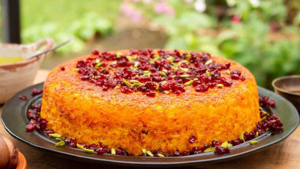 „Tahchin – persischer Safran-Reiskuchen mit Huhn, goldener Kruste und Joghurt, serviert auf orientalischem Teller.“