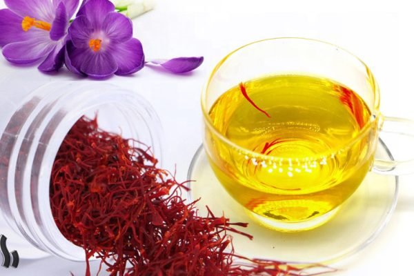 Reiner Safran Tee in einer Glas- oder Keramiktasse mit klarer goldgelber Farbe, zubereitet aus leicht zerstoßenen Safranfäden ohne Teeblätter.